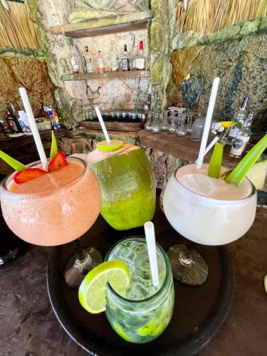 a group of three cocktails sitting on a table at Sueños Tulum in Tulum