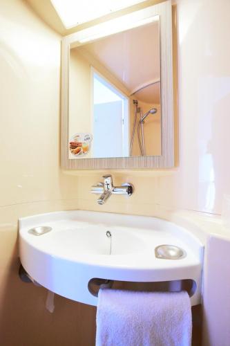 a bathroom with a white sink and a mirror at Première Classe Paris Ouest - Pont de Suresnes in Suresnes