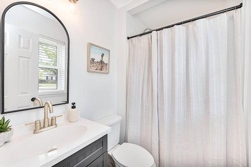 a bathroom with a sink and a toilet and a mirror at House of Kaktos located in Central Wilmington. Sleeps 8 in Wilmington