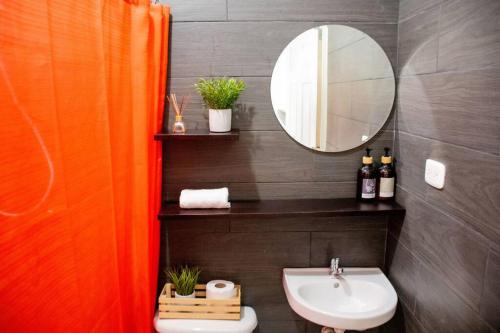 a bathroom with a sink and a mirror at Habitacion Fuego - Villa Valle Campo in Nahuizalco