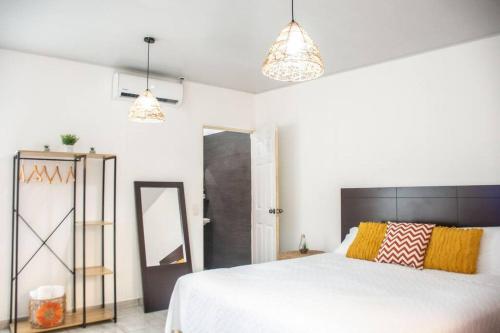 1 dormitorio con 1 cama blanca grande y 2 luces en Habitacion Fuego - Villa Valle Campo 
