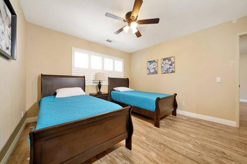 Un dormitorio con dos camas y un ventilador de techo. en Pool-BBQ-View-Balcony-Fireplace-King-Garage-WD, en Lake Elsinore