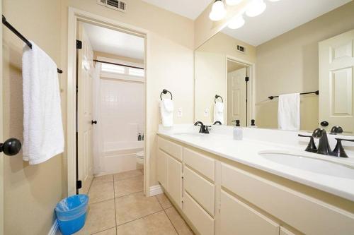 Un baño con lavabo, inodoro y espejo. en Pool-BBQ-View-Balcony-Fireplace-King-Garage-WD, en Lake Elsinore