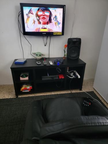 a television sitting on top of a black entertainment center at Casa espaciosa con Jacuzzi, área sur PR in Juana Diaz