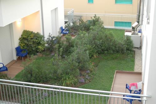 a balcony with a garden with bushes and chairs at Hotel Miramare in Pineto