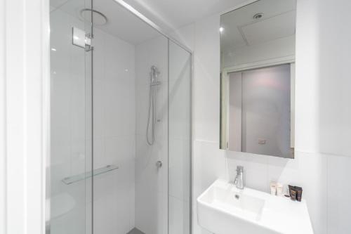 a bathroom with a shower and a sink and a mirror at Aura2107, CBD Entire 2 Bedroom Apartment with Balcony and Stunning Yarra River Views in Melbourne