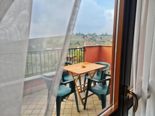 einen Tisch und Stühle auf einem Balkon mit Aussicht in der Unterkunft Il Posticino D'oltrepò in Calghera