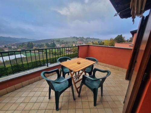 einen Tisch und Stühle auf einem Balkon mit Aussicht in der Unterkunft Il Posticino D'oltrepò in Calghera