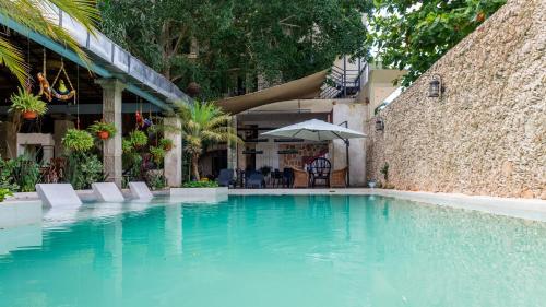 a large blue swimming pool next to a building at Hotel Nojoch che in Cobá