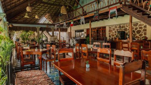 a restaurant with wooden tables and chairs in a room at Hotel Nojoch che in Cobá