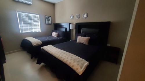 a bedroom with two beds and a window at Sofia apartment in Puerto Peñasco