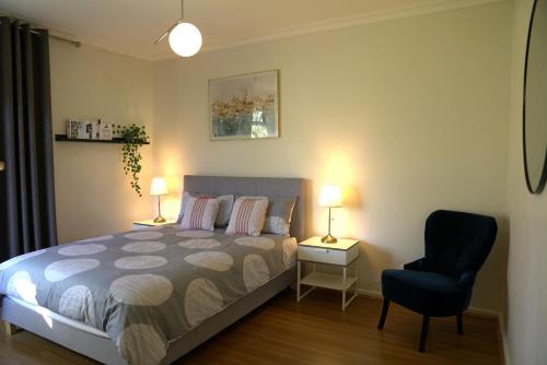 1 dormitorio con 1 cama, 1 silla y 2 lámparas en Family home in Prime location Melbourne, en Fern Tree Gully