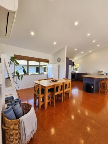 a kitchen and dining room with a wooden table at Easy Days Hahei in Hahei