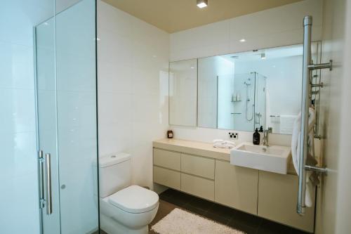 a bathroom with a toilet and a sink and a shower at Lakeside Road - Sleeps 8 - Lake Views - Lake Front in Wanaka