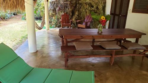 una mesa de madera y un banco con un jarrón de flores en La Cueva Eco-Lodge en Las Galeras
