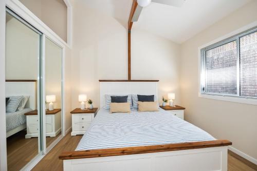 1 dormitorio blanco con 1 cama grande y 2 lámparas en Family Tides, en Ulladulla