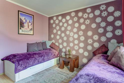 バンスコにあるGondola Flat Number 2の紫のシーツが備わる客室内のベッド2台