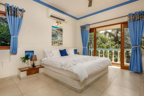 um quarto com uma cama e uma grande janela em Casa de Amor em Anjuna