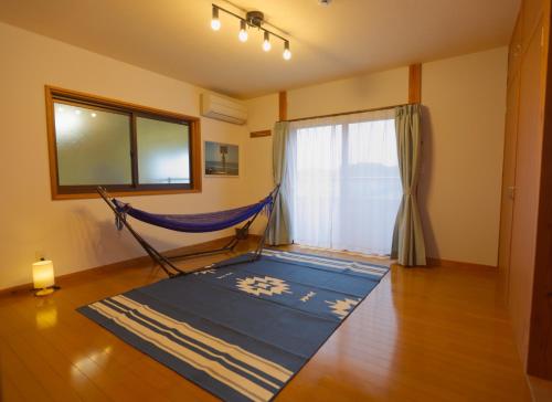 una hamaca en una sala de estar con ventana en ocean villa mint 満天の星空とオーシャンビューで心満たす一棟まるごと貸切別荘, en Chikura