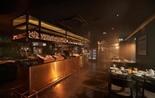 a restaurant with a counter with food on it at The Ember Hotel in Bangkok