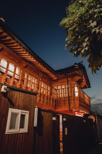 a cabin with a deck on the side of it at StayAnGim in Gyeongju