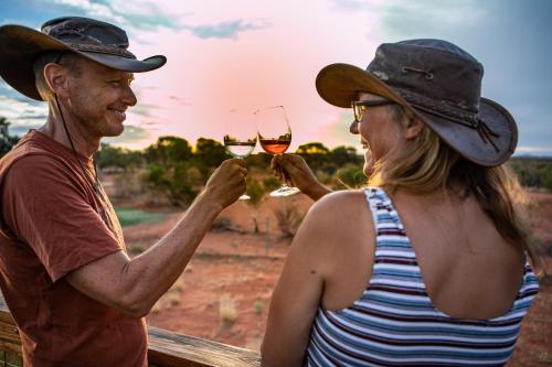 a man and a woman holding glasses of wine at Erldunda Desert Oaks Resort in Erldunda