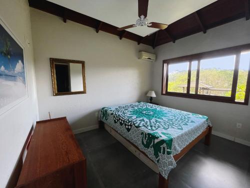 1 dormitorio con cama y ventana en Casa de praia no Rosa - vista para Lagoa de Ibiraquera, en Imbituba