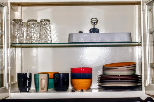 a shelf with plates and bowls and other dishes at Crystoural Apartment Liguanea Sovereign Apt - 2 Bedrooms, 3 Beds, Host 4 Guest- Kingston! in Kingston