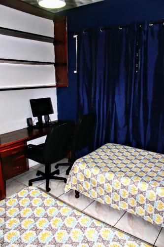 a bedroom with two beds and a desk and a desk at Crystoural Apartment Liguanea Sovereign Apt - 2 Bedrooms, 3 Beds, Host 4 Guest- Kingston! in Kingston