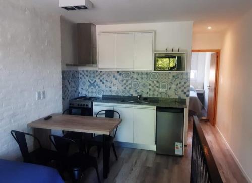a kitchen with a wooden table and a kitchen with white cabinets at PH playa Grande in Mar del Plata