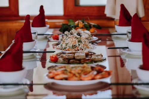 a long table with plates of food on it at Cat Ba Bay Cruises in Cat Ba
