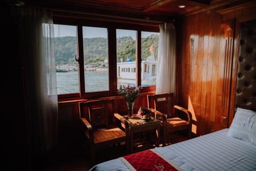 a bedroom with a bed and a table and a boat at Cat Ba Bay Cruises in Cat Ba