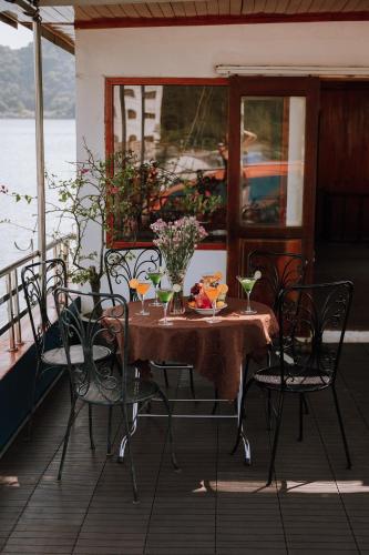 a table and chairs on a deck of a boat at Cat Ba Bay Cruises in Cat Ba