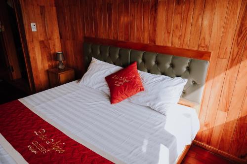 a bed with two red and white pillows on it at Cat Ba Bay Cruises in Cat Ba