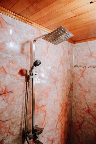 a shower in a bathroom with a marble wall at Cat Ba Bay Cruises in Cat Ba