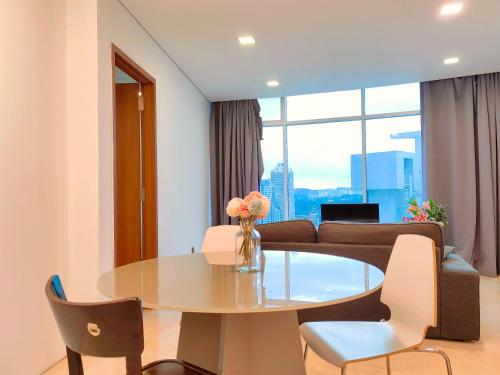 uma sala de estar com uma mesa e um sofá em Vortex Suites KLCC By Welt em Kuala Lumpur