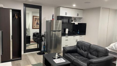 een woonkamer met een bank en een koelkast bij Modern & Luxurious Suites in Surrey in Surrey