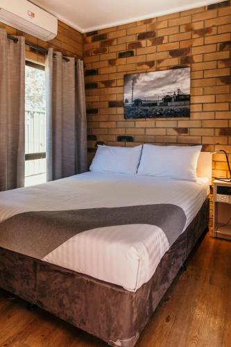 Ένα ή περισσότερα κρεβάτια σε δωμάτιο στο Abacus Motel
