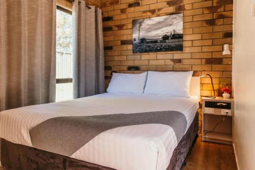 Ένα ή περισσότερα κρεβάτια σε δωμάτιο στο Abacus Motel