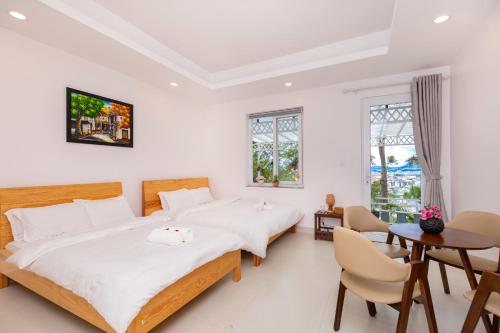 a bedroom with two beds and a table and chairs at Villa Trung Nghĩa 31 in Da Lat