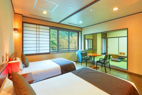 a hotel room with two beds and a table and chairs at KAMENOI HOTEL SHIOBARA Dog Friendly Hotel in Nasushiobara