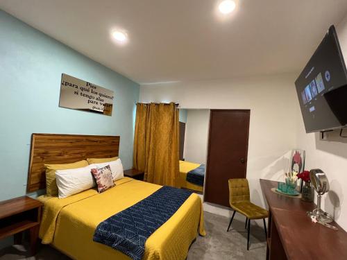 a bedroom with a bed and a desk and a television at Mini loft “FRIDA” in La Paz