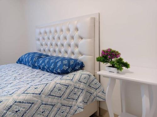 a bed with a blue and white quilt and a pillow at Apartamento Roldanillo pueblo mágico in Roldanillo