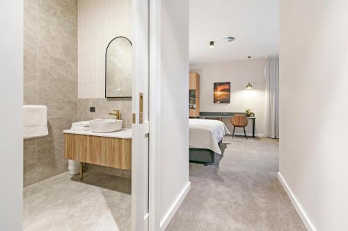 a bathroom with a sink and a bed in a room at The Tanunda Club Guest Suites in Tanunda