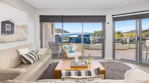 a living room with a couch and a table at Solaris in Fingal Bay