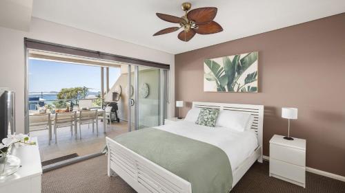 a bedroom with a bed and a ceiling fan at Solaris in Fingal Bay