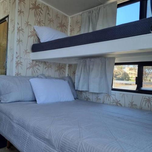 Bett in einem Zimmer mit 2 Etagenbetten in der Unterkunft The one & only Houseboat Hire on Maroochy River in Maroochydore