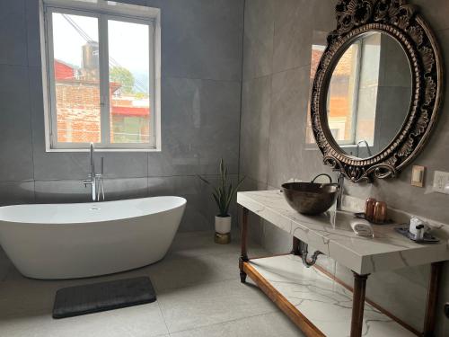 Hotel Mi Solar Centro في اروابان دل بروغرسو: حمام مع حوض استحمام أبيض ومرآة