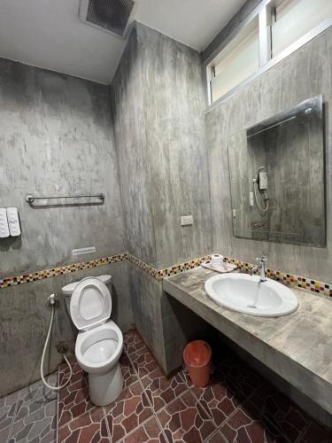 La salle de bains est pourvue de toilettes et d'un lavabo. dans l'établissement โรงแรมช้างใหญ่ใจดี, à Yasothon