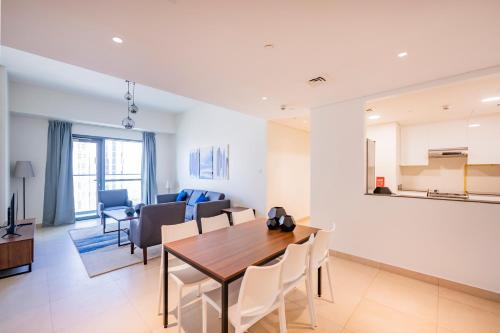 a dining room and living room with a table and chairs at Expo Village Serviced Apartments in Dubai